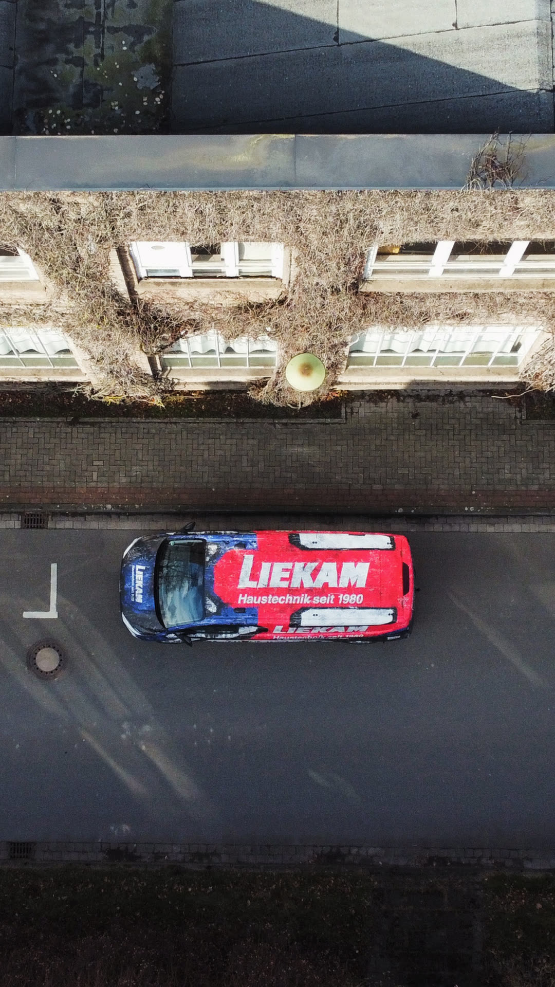 Drohnen-Topshot LIEKAM Transit Custom mit rot-blauem Wrap