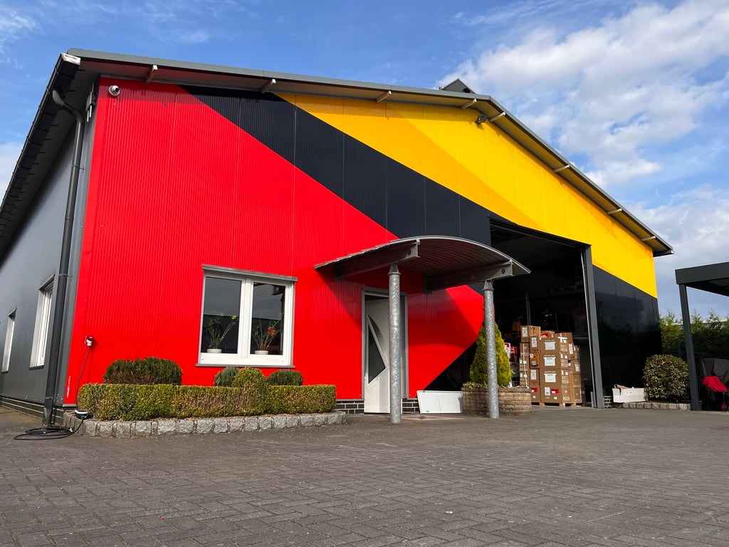 Werkstatt-Fassade mit Schwarz-Rot-Gelb-Wrap