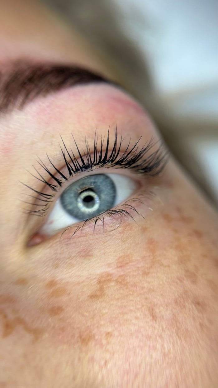 Nahaufnahme eines blauen Auges mit stark geschwungenen Wimpern