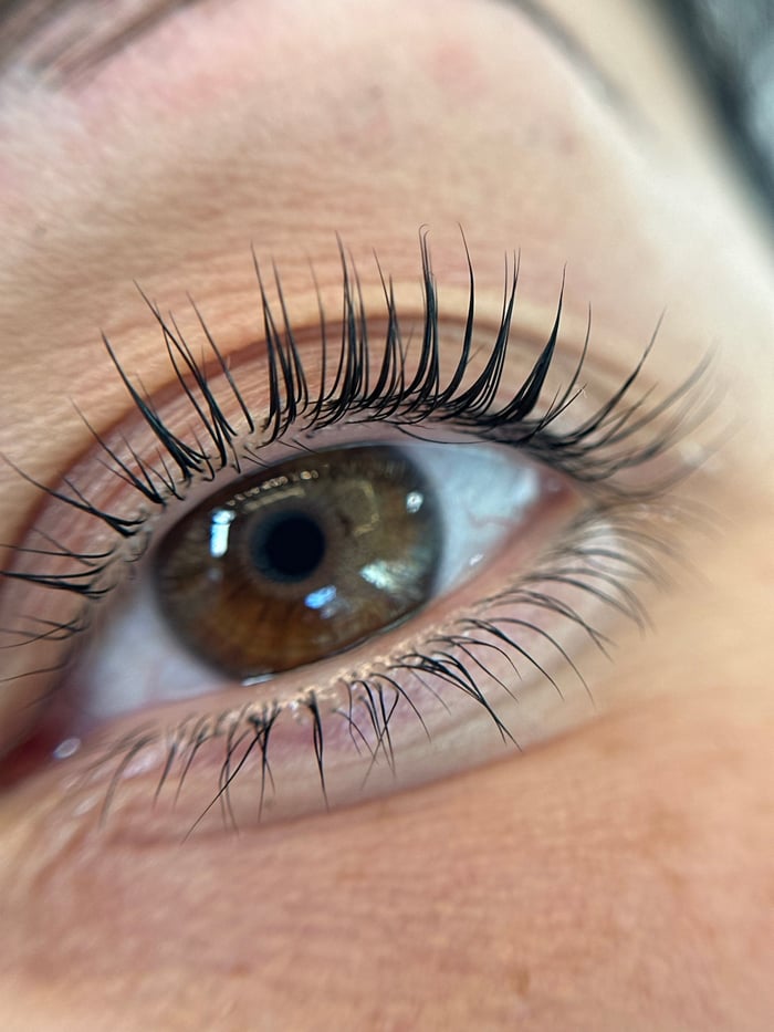 Detailaufnahme eines braunen Auges mit geschwungenen Wimpern nach Lash Lift