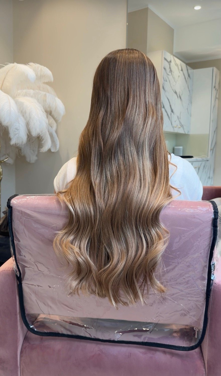 Balayage von dunklem Ansatz zu blonden Spitzen mit glänzenden Wellen