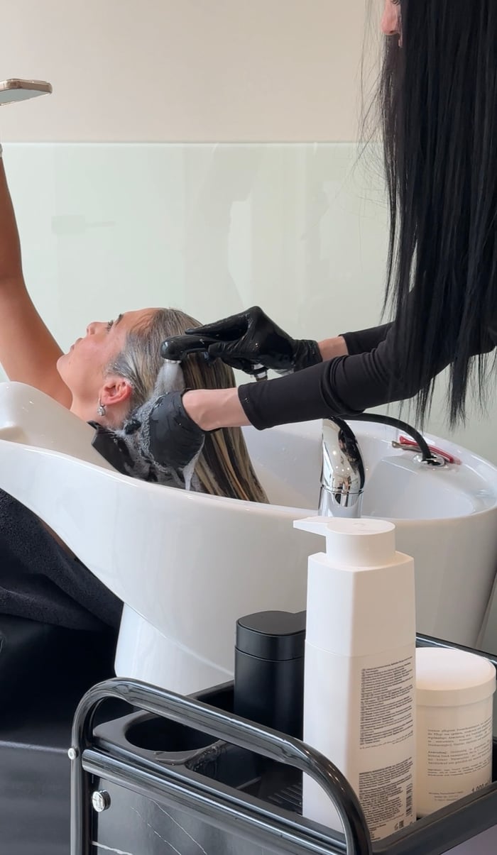Stylistin spült die Coloration am Waschbecken aus
