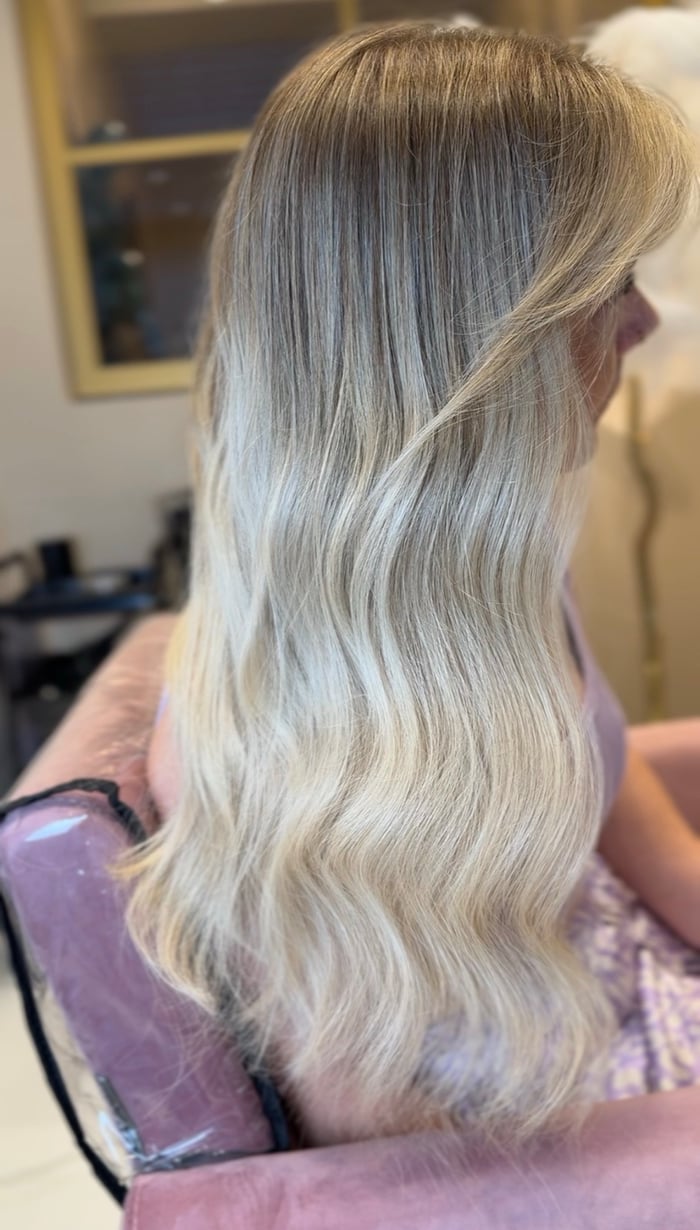 Volle, lange blonde Mähne mit weichen Wellen nach der Haarverlängerung