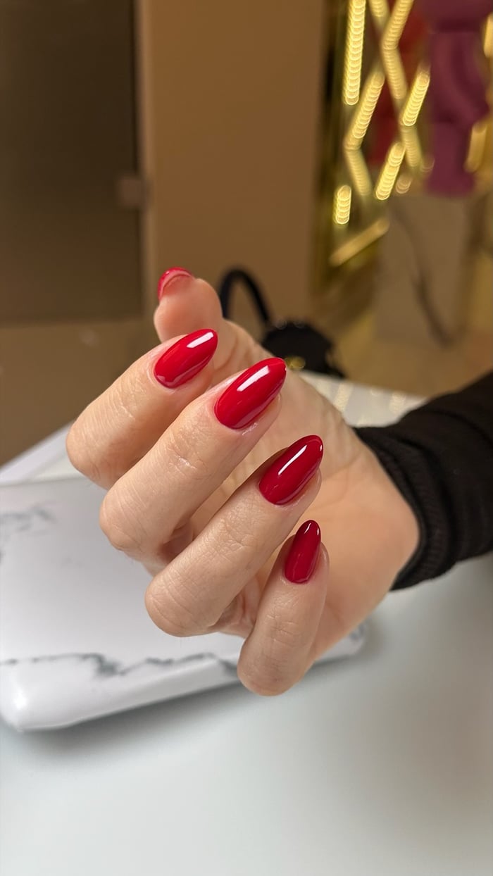 Rote Gelnägel in Mandelform mit Hochglanz, elegante Maniküre