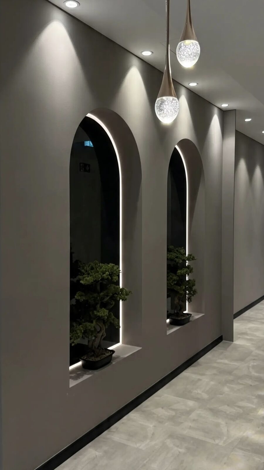 Beleuchtete Bogennischen mit Bonsai im Flur des HYPE Studios