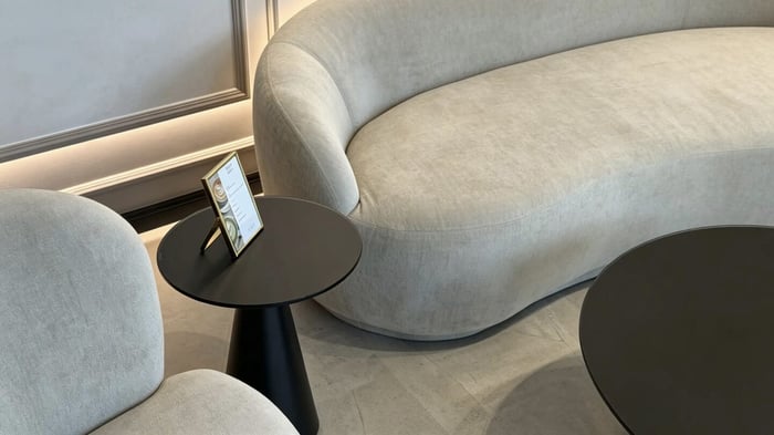 Geschwungenes Sofa mit Beistelltisch und Getränkekarte in der HYPE Lounge