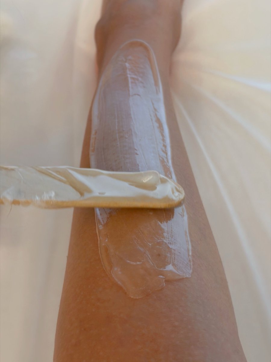 Professionelles Sugaring am Bein, Zuckerpaste wird mit Spatel aufgetragen