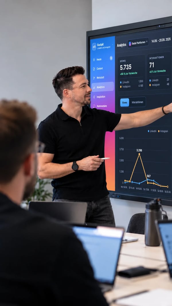 Workshop: Ein Trainer erklärt einer Gruppe an Laptops ein Auswertungs-Dashboard auf dem Bildschirm