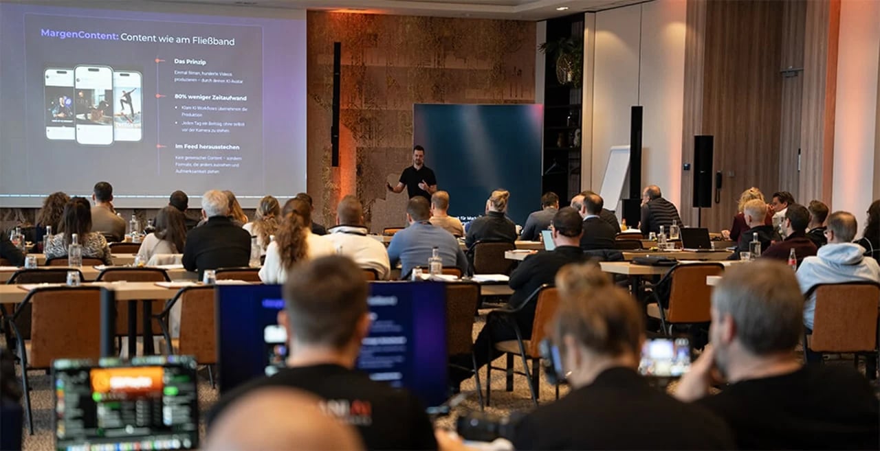 Gordon Wolfertz bei einem Vortrag vor vollem Saal, auf der Leinwand eine Folie zur Content-Produktion