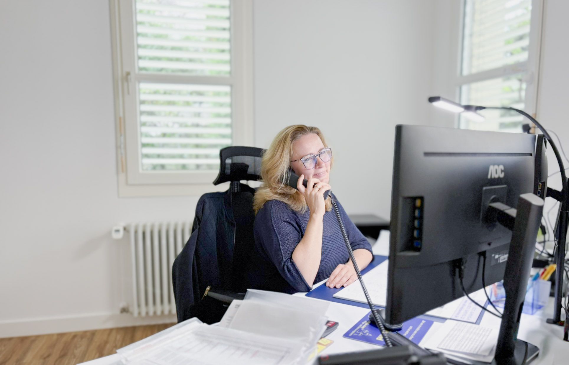 Mitarbeiterin der regio.care Verwaltung am Telefon