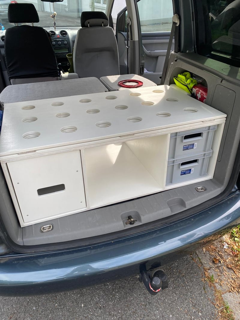 Camper-Ausbau mit weißem Holzmodul, Bettauszug und Schubladen