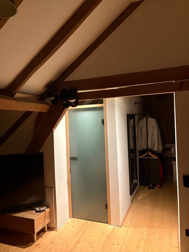 Eingebaute Glastür mit Holzzarge im Dachgeschoss