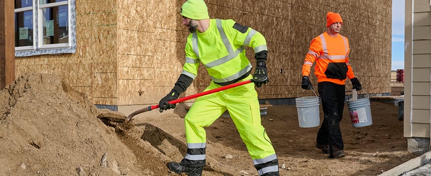 Two men working in hivis on an outdoor jobsite.