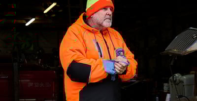 A man working in snow in waterproof pants.