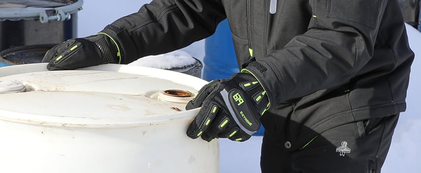 Person wearing impact-resistant work gloves moves a barrel.