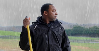 A man working safely in the rain.