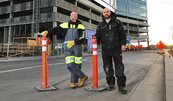 Men working on road construction in the winter wear insulated bib overalls and insulated pants to stay warm.