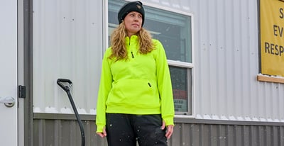 A woman in HiVis Quarter-Zip Fleece Sweatshirt outdoors.