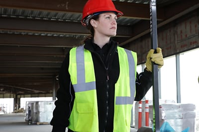 A woman working outside in hivis vest.