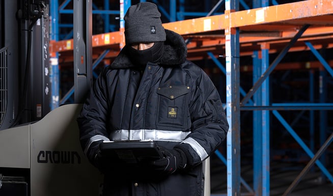 Person wearing insulated freezer suit works in a freezer warehouse.
