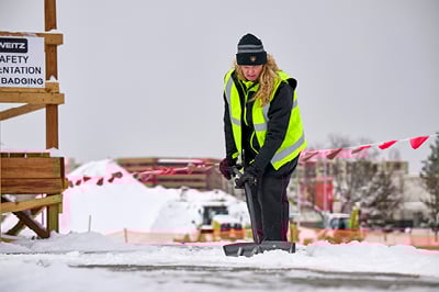 A woman working in lime hivis vest.