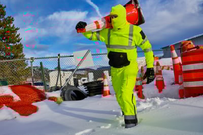 A man working in snow in waterproof pants.