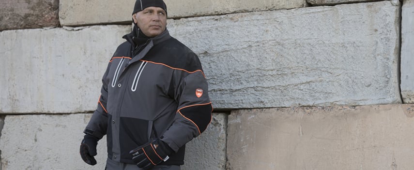 Man wearing insulated softshell jacket works outside in extreme cold temperatures.