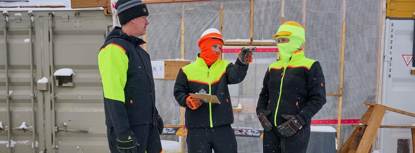 3 men wearing RefrigiWear FrostFlex talking on a cold construction site