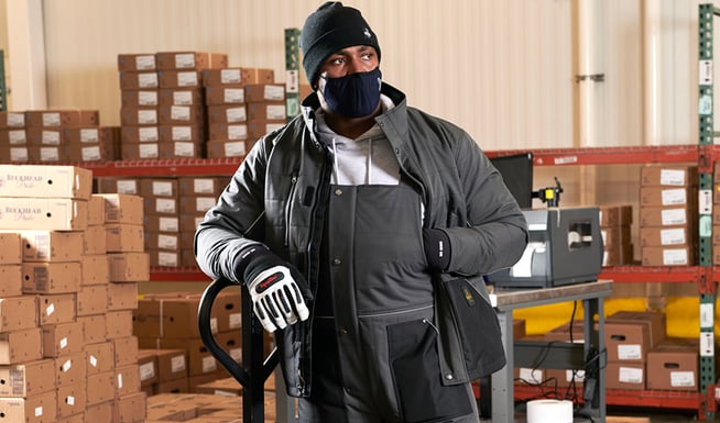 Man working in a refrigerated warehouse uses multiple layers to stay warm.