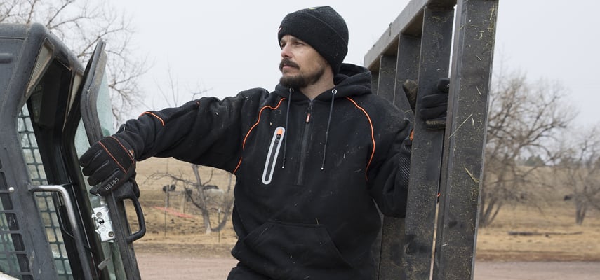 Man wearing RefrigiWear working outdoors on heavy equipment.