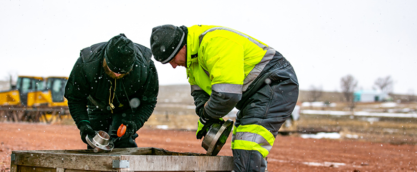 Men working outside in cold, wet weather wear insulated, water-repellent workwear.