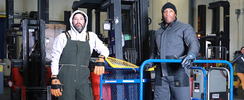 Men working in a refrigerated warehouse wear insulated bib overalls, thermal sweatshirts and heavy-duty work jackets.