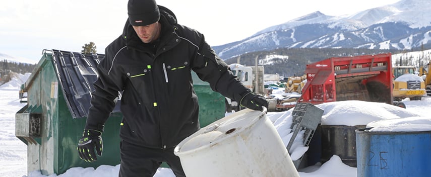 Man wearing an insulated work coat with an interior adjustable waist works outside in winter.