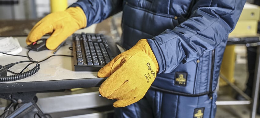 Person wearing Key-Rite insulated work gloves uses a keyboard.