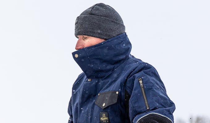 Man works outside dressed in draft-reducing cold-weather work clothes from RefrigiWear.