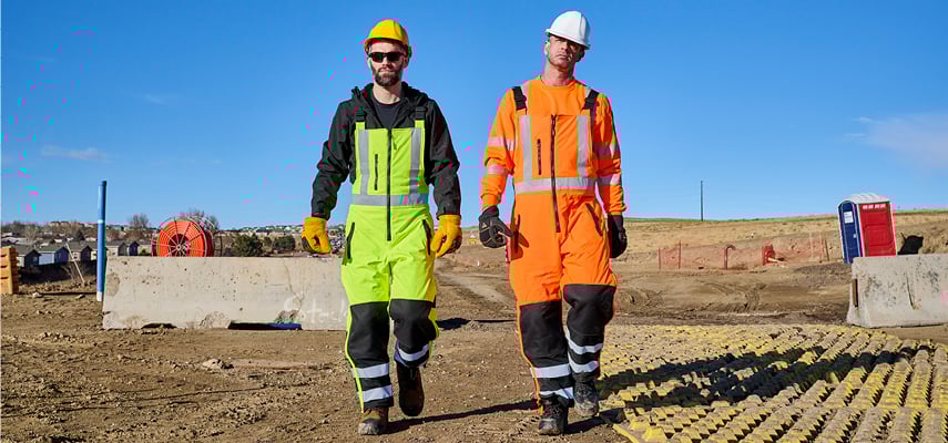 Two men walking in hivis workwear on an construction job site.