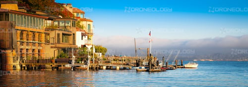 Picture at Sunset of Corinthian Island Homes with a fogged in San Francisco cityscape in the background taken from Tiburon, California.