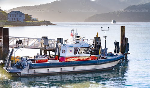 Picture of the Tiburon Fire and Rescue Boat docked with Angel Island ferry in the background in Tiburon, California.