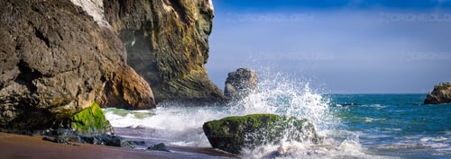 Picture of Tennessee Beach Cliffs At Sunset with Water Splashing on rock at Tennessee Beach, California.