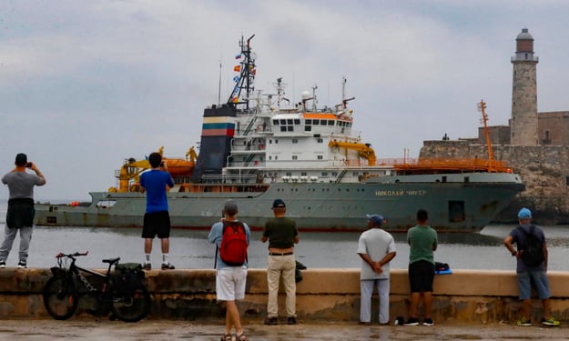 Personas observan la llegada al puerto de La Habana de un buque perteneciente a la flotilla de la Marina de Guerra de Rusia este 12 de junio de 2024. EFE/Yander Zamora