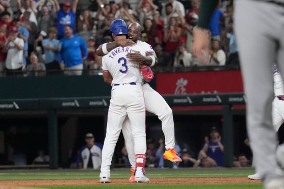 El dominicano de los Rangers de Texas, Leody Taveras (3) es abrazado por su compañero de equipo, el cubano Adolis García luego de conectar un sencillo con bases llenas para remolcar a Ezequiel Durán en el noveno episodio y ganar el juego de béisbol ante los Atléticos de Oakland, el sábado 31 de agosto, de 2024, en Arlington, Texas. (AP Foto/LM Otero)