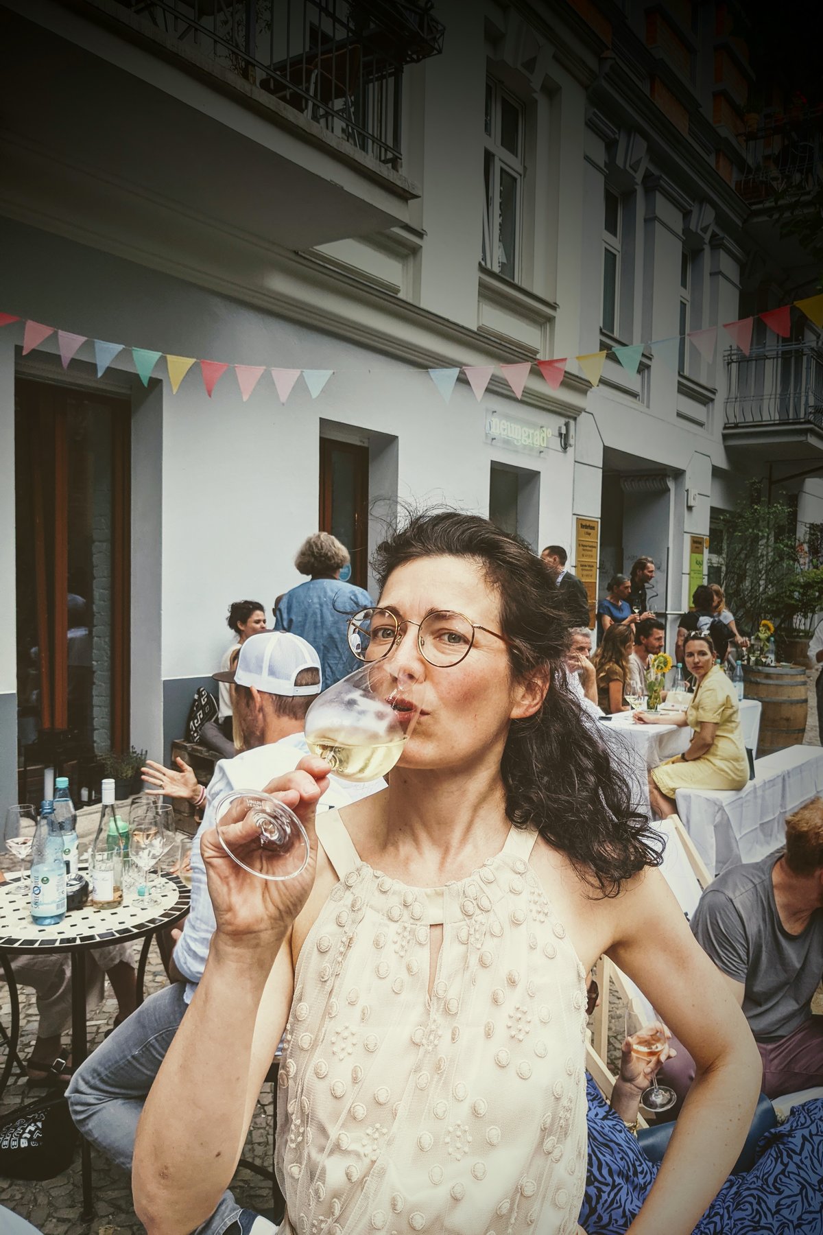 Alexandra auf einer Party im sommerlichen Dress in champagnerfarben.