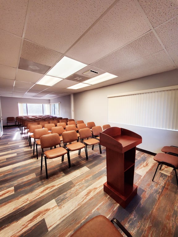 An interior shot of Event Venue with Podium, Projector & Sound, Room #201 – Up to 50 Guests