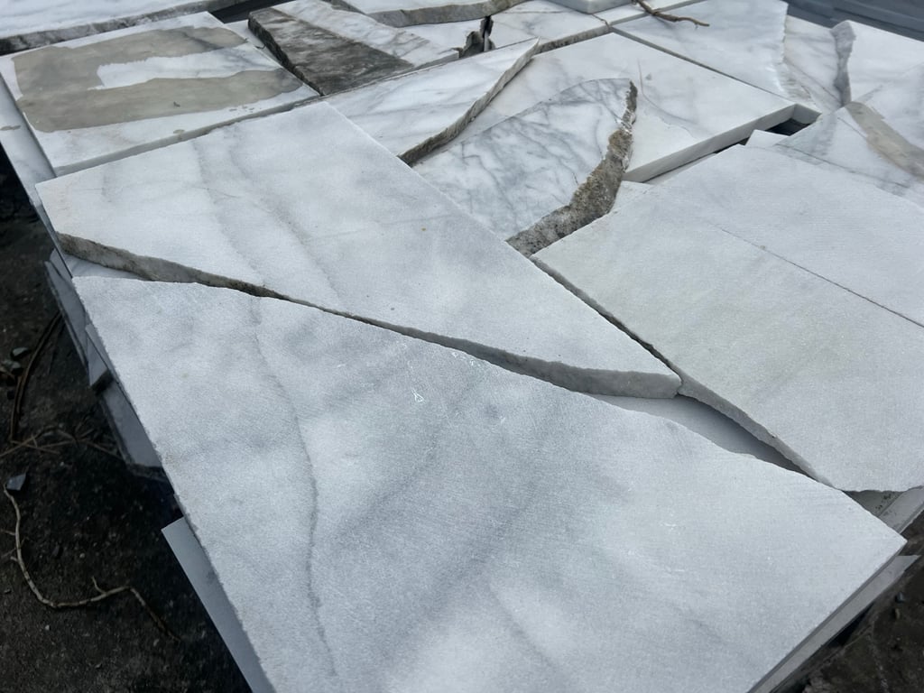 A stack of cracked and offcut marble slabs from a Hualien stone workshop