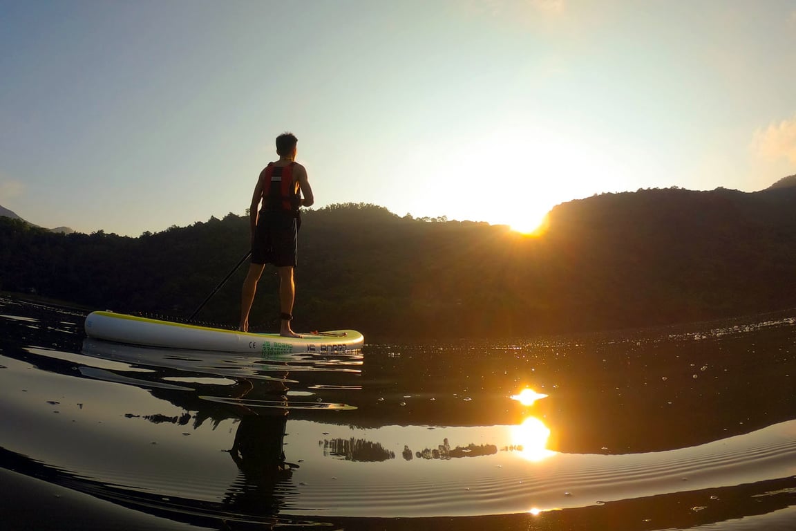 男學員 SUP 剪影站在鯉魚潭湖面, 夕陽倒映水面