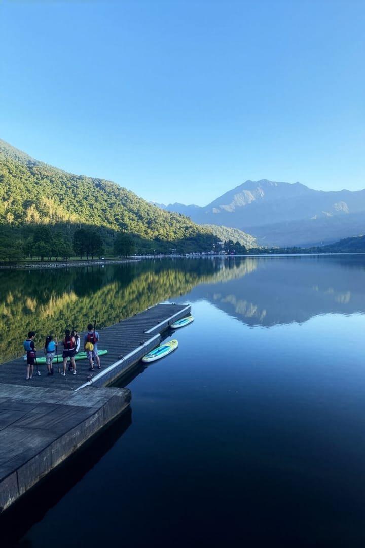 五位學員站在鯉魚潭木棧碼頭邊, 湖面如鏡倒映中央山脈稜線, 清晨光線柔和