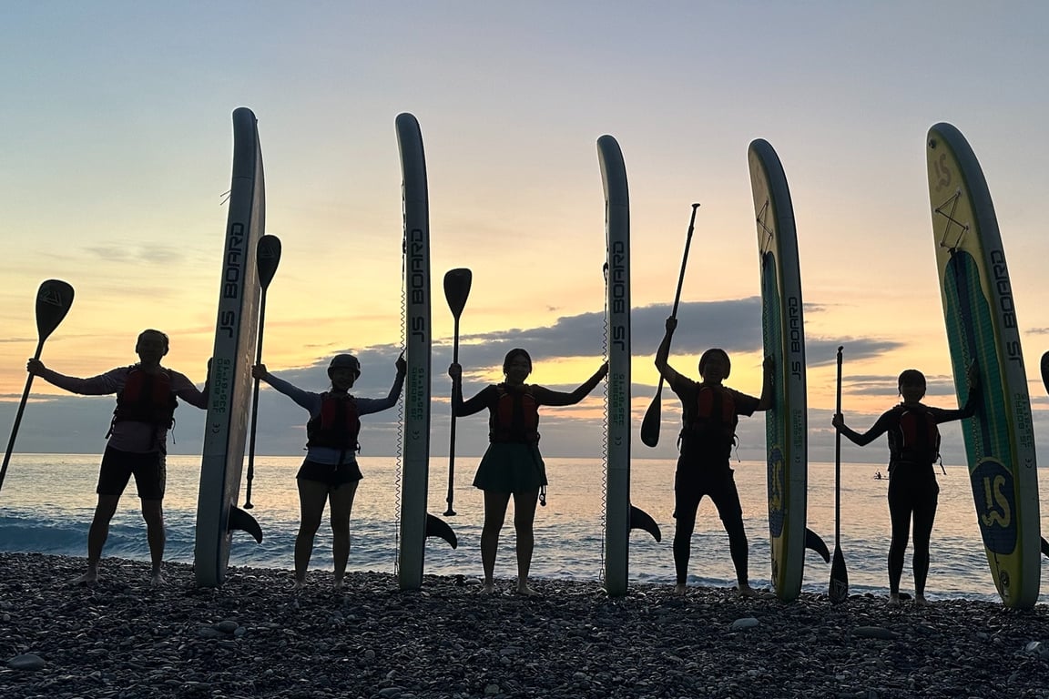 清水斷崖 SUP 六人在沙灘上舉板剪影, 背景是日出橘色雲海