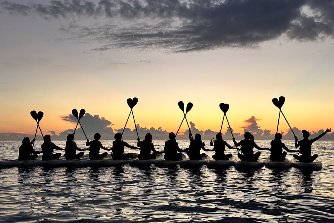 清水斷崖 SUP 12 人小團剪影, 學員手牽手坐在板上舉槳, 背景是日出橘色雲海