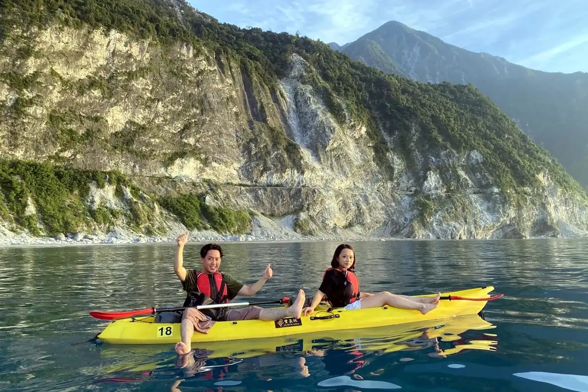 Wide-angle shot of a small group below the cliff wall — a customer photo by an Eye Travel Taiwan instructor
