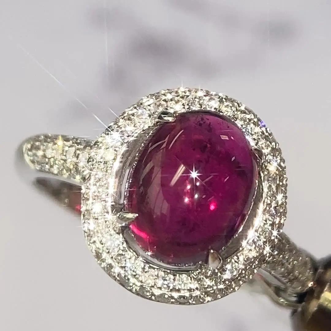 una pieza de anillo con gran gema púrpura rodeada de diamantes